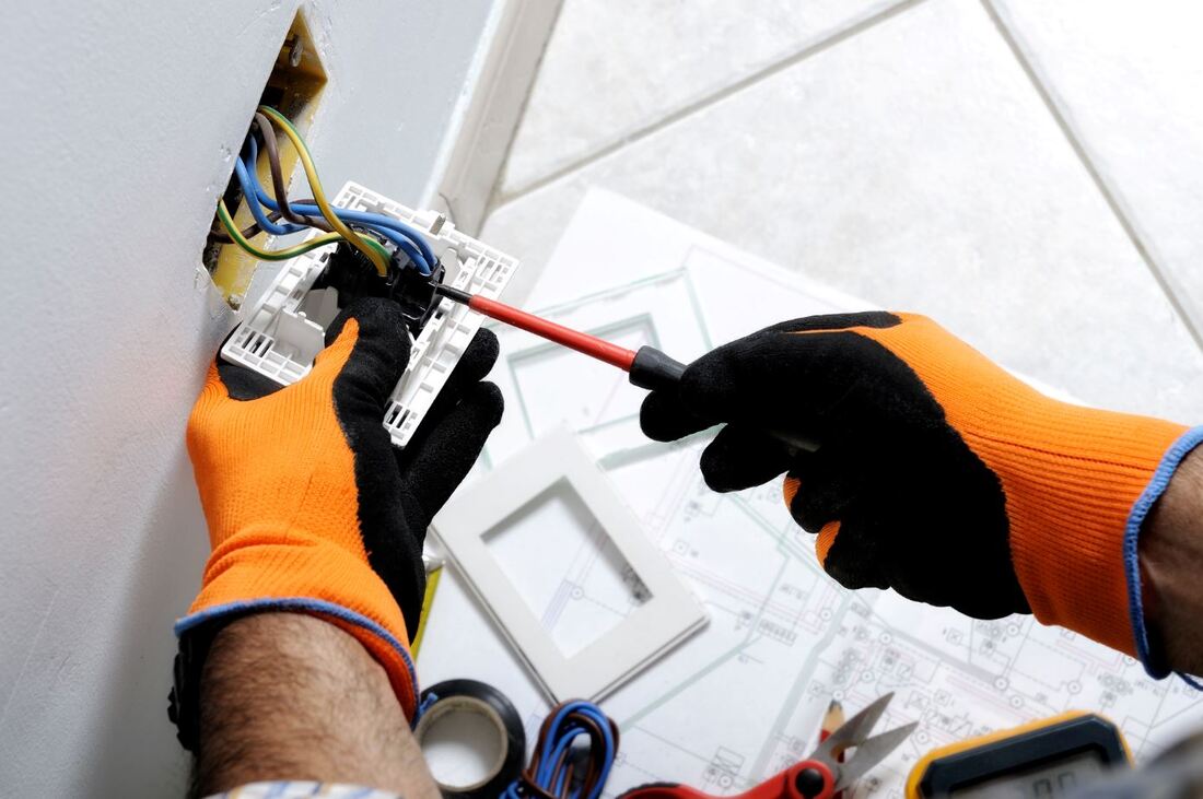 Electrician maintaining a residential electrical socket